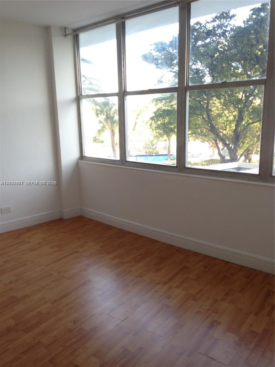 A kitchen features white cabinets, a black countertop, a stainless steel sink, and mosaic backsplash — 7441 Wayne Ave # 2O, Miami Beach FL 33141, MIAMI BEACH, FL