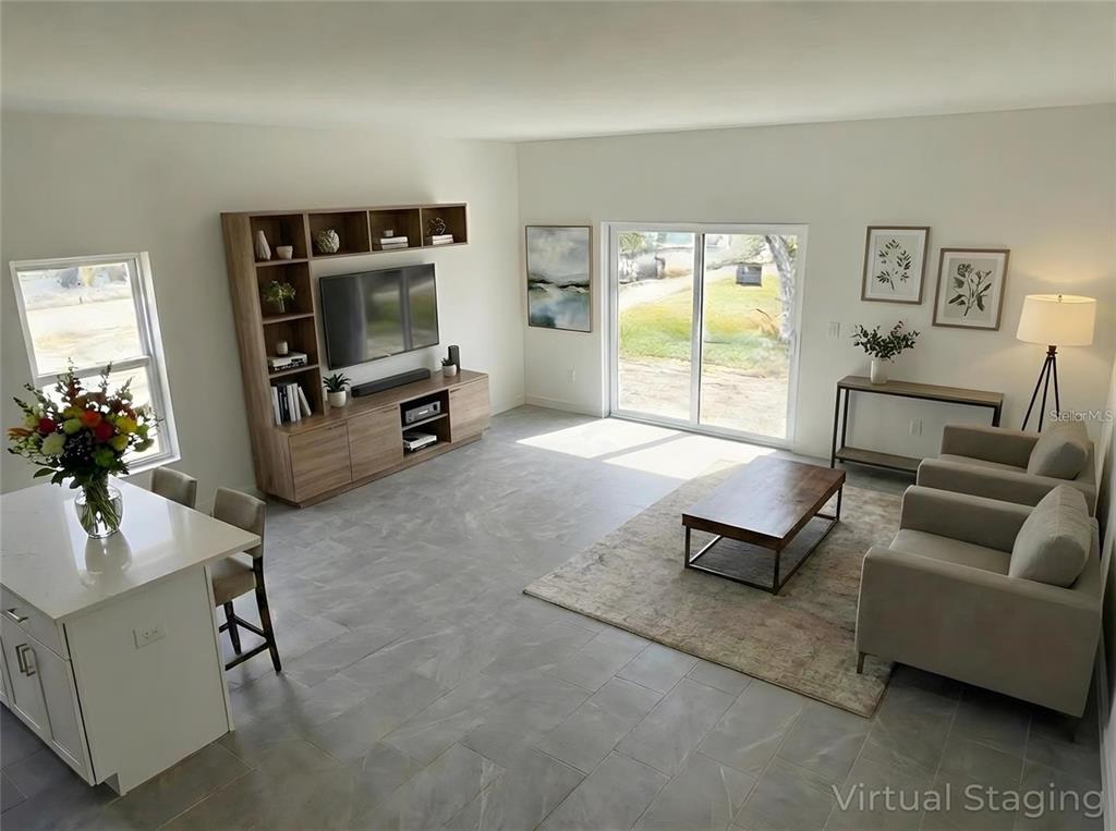 This living room features tile flooring, a built-in media console, and a sliding glass door — 1405 W 14TH STREET, SANFORD, FL