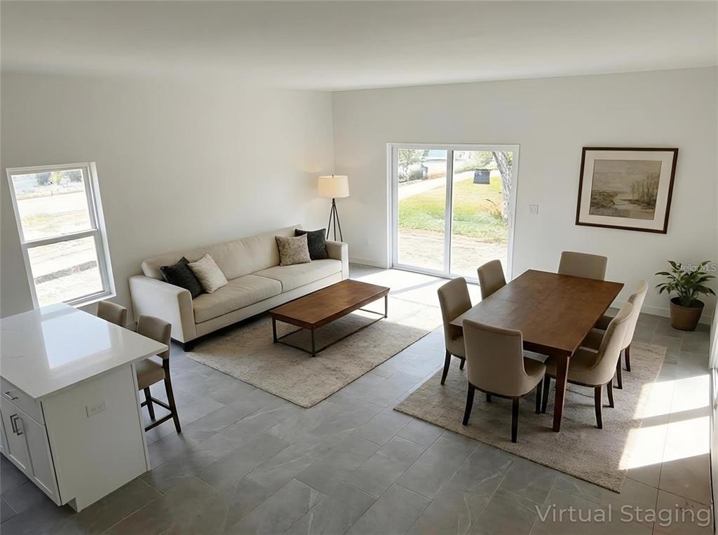 This living and dining area features tile flooring, a neutral sofa, and a wooden table — 1405 W 14TH STREET, SANFORD, FL