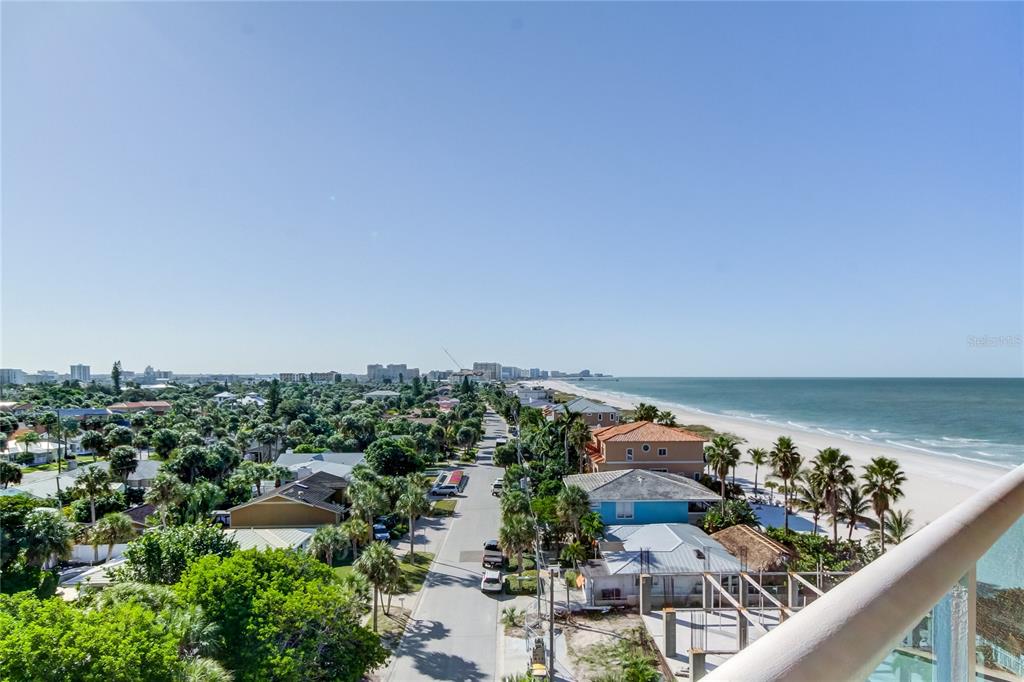 An elevated view shows a coastal street, residential homes, and a sandy beach — 880 MANDALAY AVENUE UNIT 604, CLEARWATER BEACH, FL