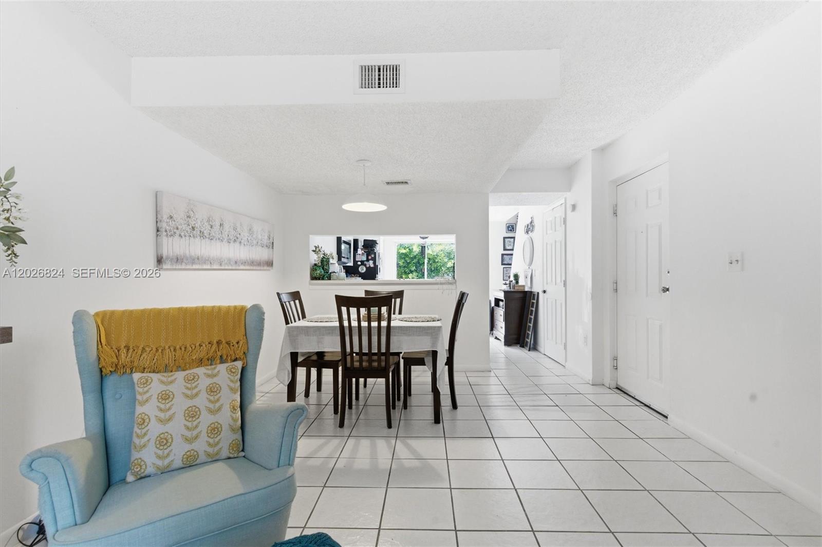 A dining area with a table and chairs sits adjacent to a living room space — 8240 SW 149th Ct # 201, Miami FL 33193, MIAMI, FL