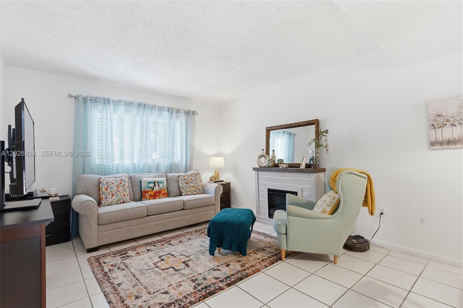 A living room features a gray sofa, a light blue armchair, and a fireplace — 8240 SW 149th Ct # 201, Miami FL 33193, MIAMI, FL