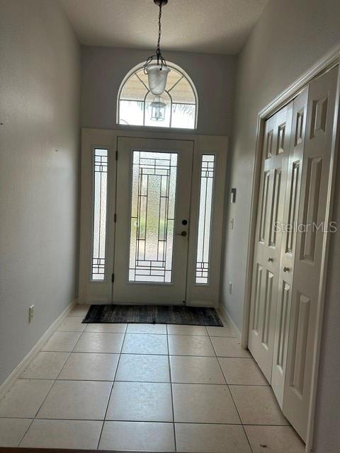 An entryway features a front door with sidelights, a transom window, and a tile floor — 992 RIDGELAND PATH, THE VILLAGES, FL