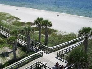 An elevated view of a wooden boardwalk leading to a sandy beach and the ocean — 7177 BOUGAINVILLEA STREET, ENGLEWOOD, FL
