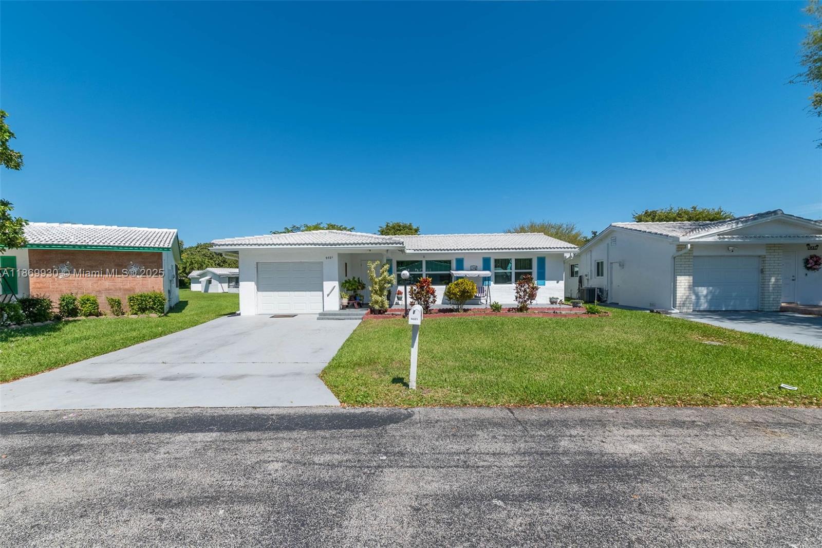 A single-story white house with a garage, a front lawn, and a concrete driveway — 9021 NW 13th St, Plantation FL 33322, PLANTATION, FL