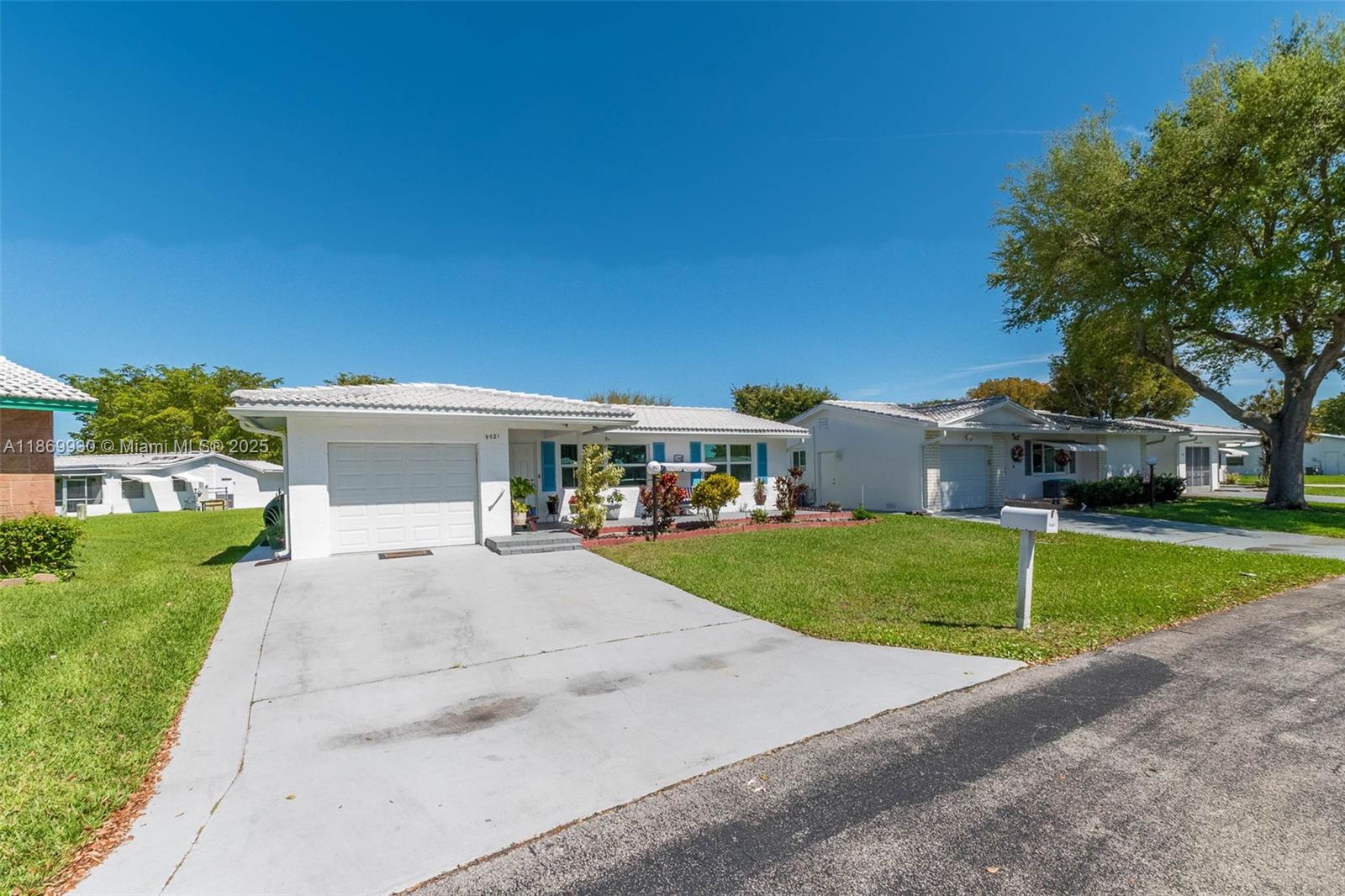 A single-story white house with a garage and a front lawn under a clear sky — 9021 NW 13th St, Plantation FL 33322, PLANTATION, FL