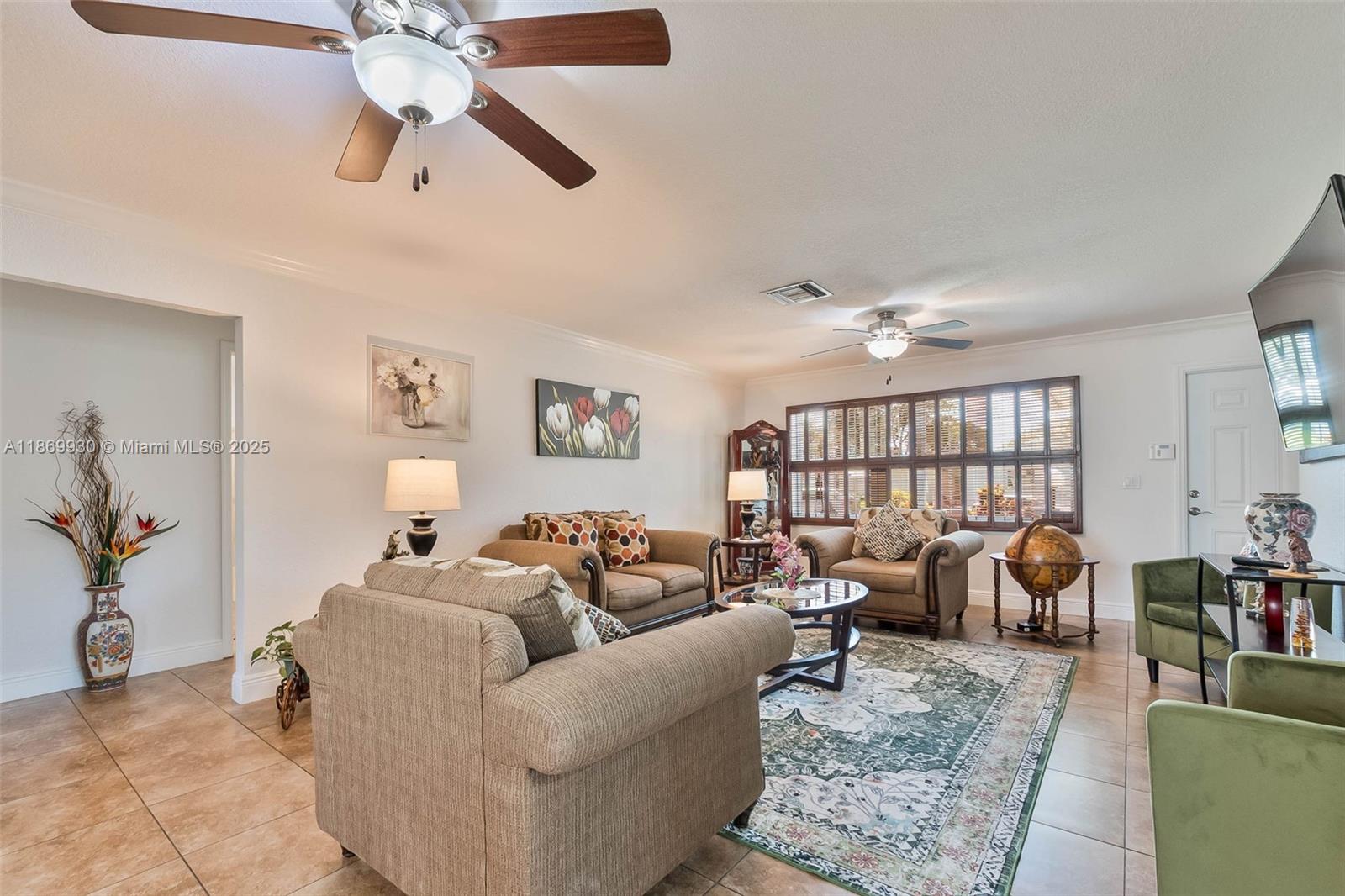A living room features tile flooring, a ceiling fan, and a patterned area rug — 9021 NW 13th St, Plantation FL 33322, PLANTATION, FL