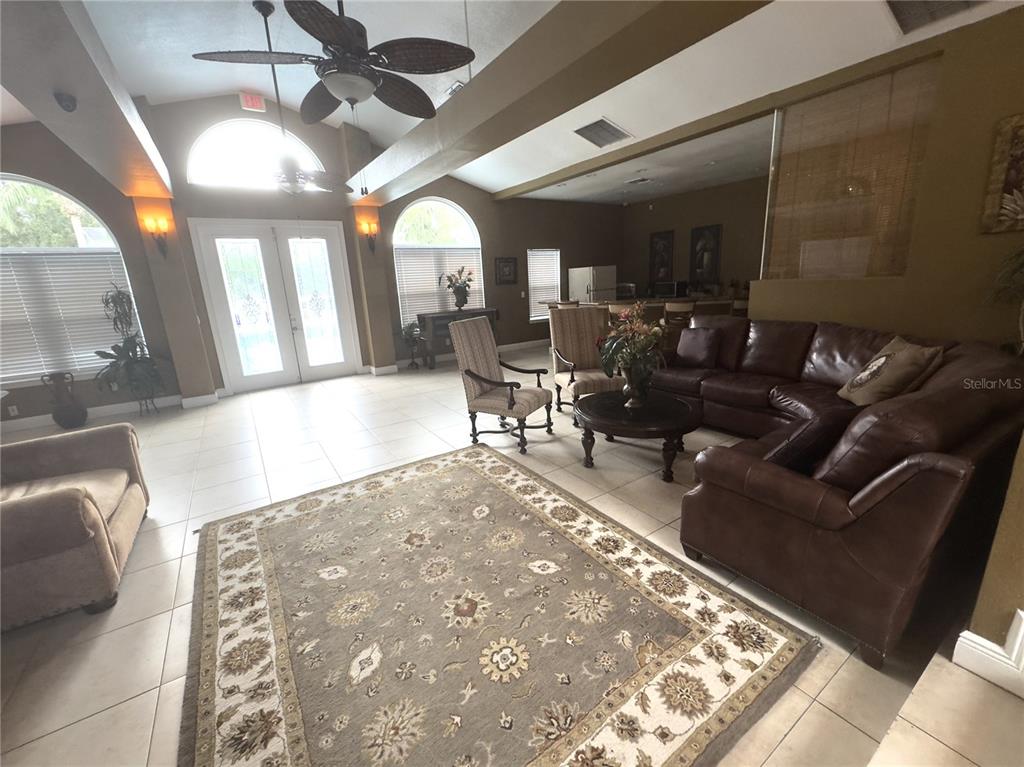A spacious living room features tile floors, a large area rug, and leather furniture — 2504 GRASSY POINT DRIVE UNIT 202, LAKE MARY, FL
