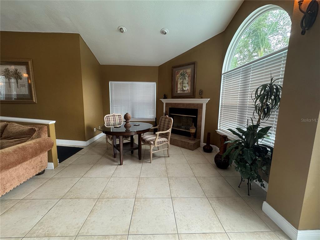 A dining area features tile flooring, a fireplace, and large windows with blinds — 2504 GRASSY POINT DRIVE UNIT 202, LAKE MARY, FL