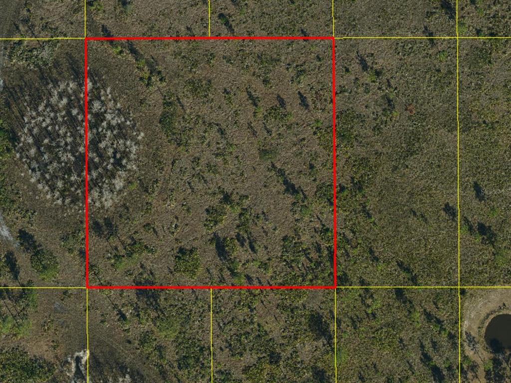 An aerial view shows a rectangular plot of land outlined in red on a map — HOLOPAW GROVES ROAD, ST CLOUD, FL