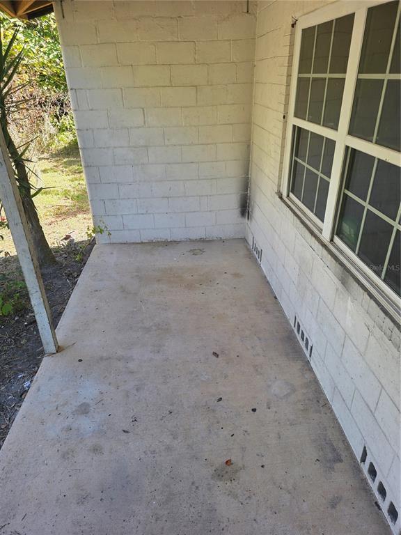 A concrete porch with white painted block walls and a window on the right side — 22629 SE 71ST AVENUE, HAWTHORNE, FL