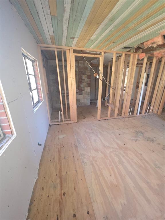 An unfinished room under renovation features exposed wall studs, plywood flooring, and a wood-plank ceiling — 22629 SE 71ST AVENUE, HAWTHORNE, FL