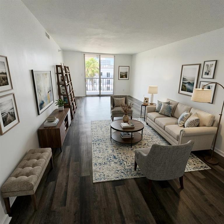 A living room features wood-look flooring, a beige sofa, two armchairs, and a balcony view — 201 W LAUREL STREET UNIT 703, TAMPA, FL