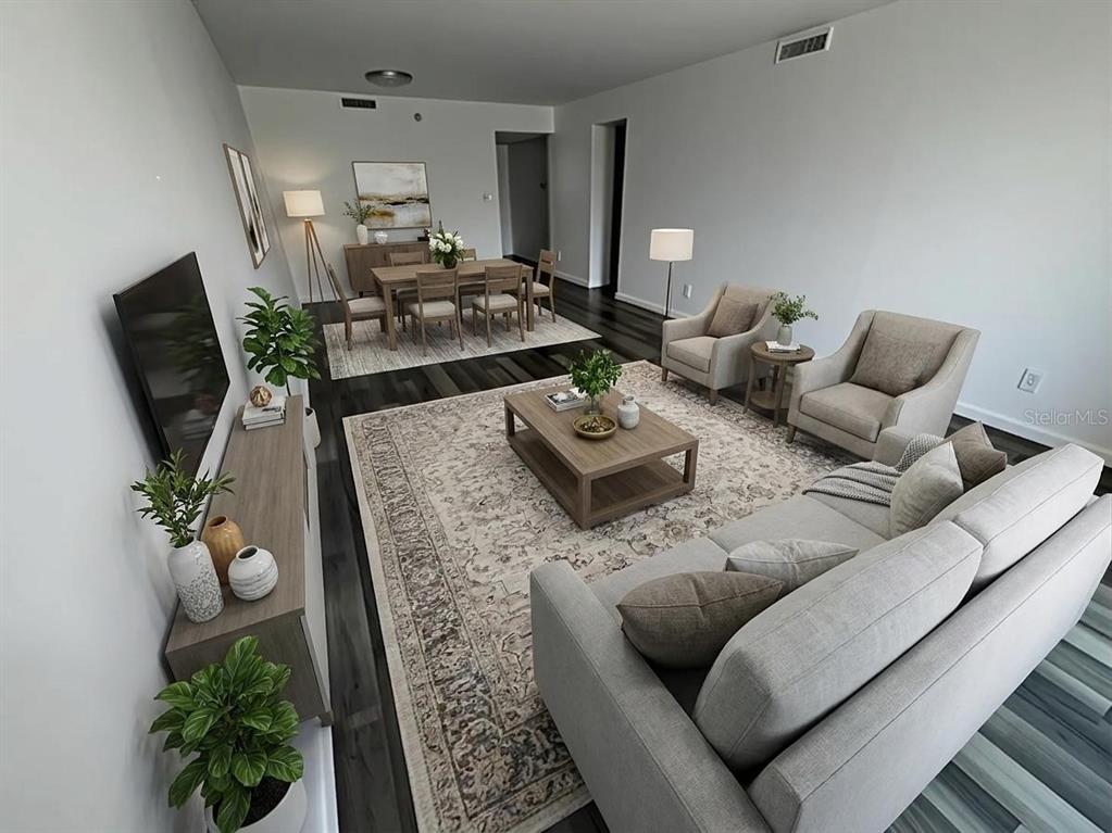 A living and dining room with wood floors, neutral furniture, and a large area rug — 201 W LAUREL STREET UNIT 703, TAMPA, FL