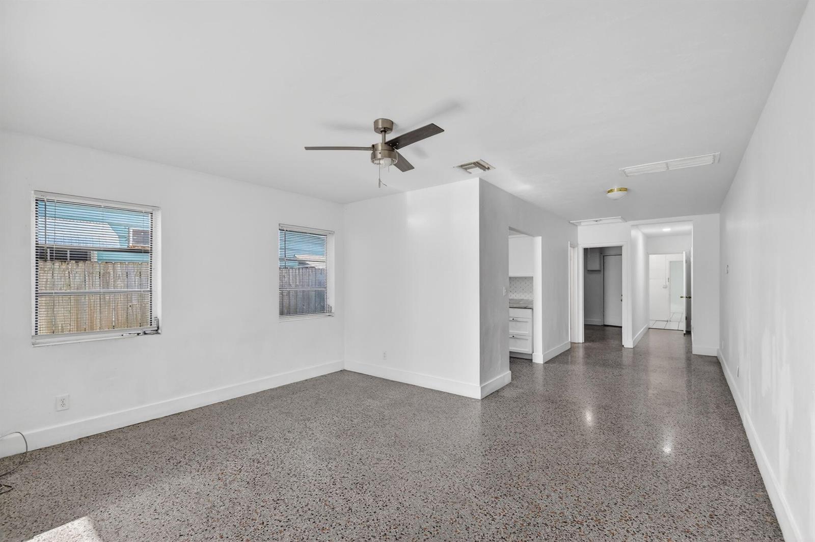 An empty room with white walls, a ceiling fan, and speckled gray flooring — 301 S L Street, FL 33460, FL