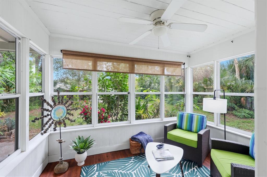 A sunroom features white walls, a ceiling fan, large windows, and two wicker armchairs — 1020 23RD STREET, SARASOTA, FL