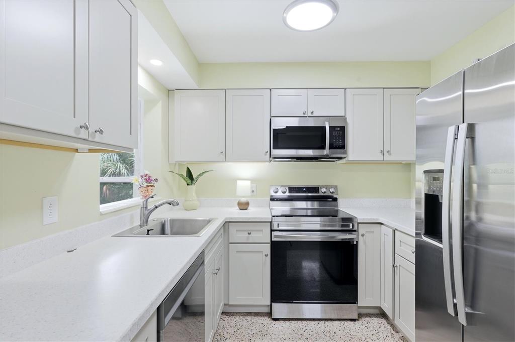 A kitchen with light-colored cabinets, stainless steel appliances, and white countertops — 1020 23RD STREET, SARASOTA, FL
