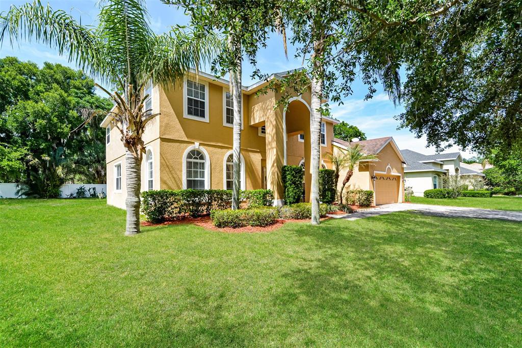A two-story yellow stucco house with an arched entryway and a two-car garage — 99 JAKE COURT, OCOEE, FL