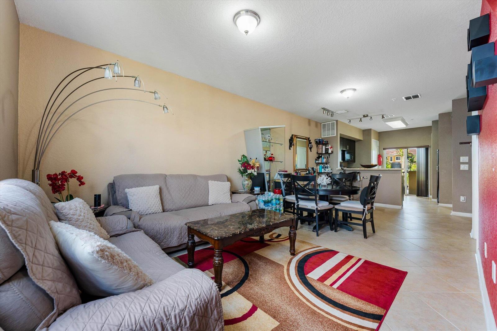 A living room with a beige sofa, marble coffee table, and dining area beyond — 131 NW 2nd Avenue # 3, FL 33009, FL