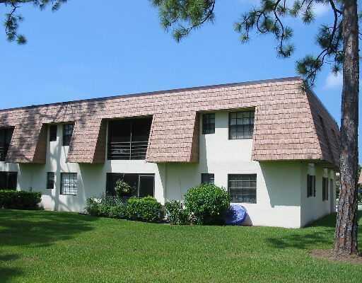 A two-story apartment building with a mansard roof, stucco walls, and a grassy lawn — 4101 Oak Terrace Drive, FL 33463, FL