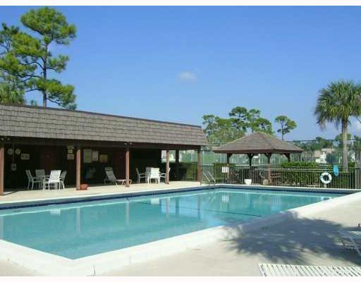 A rectangular swimming pool sits in front of a covered patio and a wooden gazebo — 4101 Oak Terrace Drive, FL 33463, FL