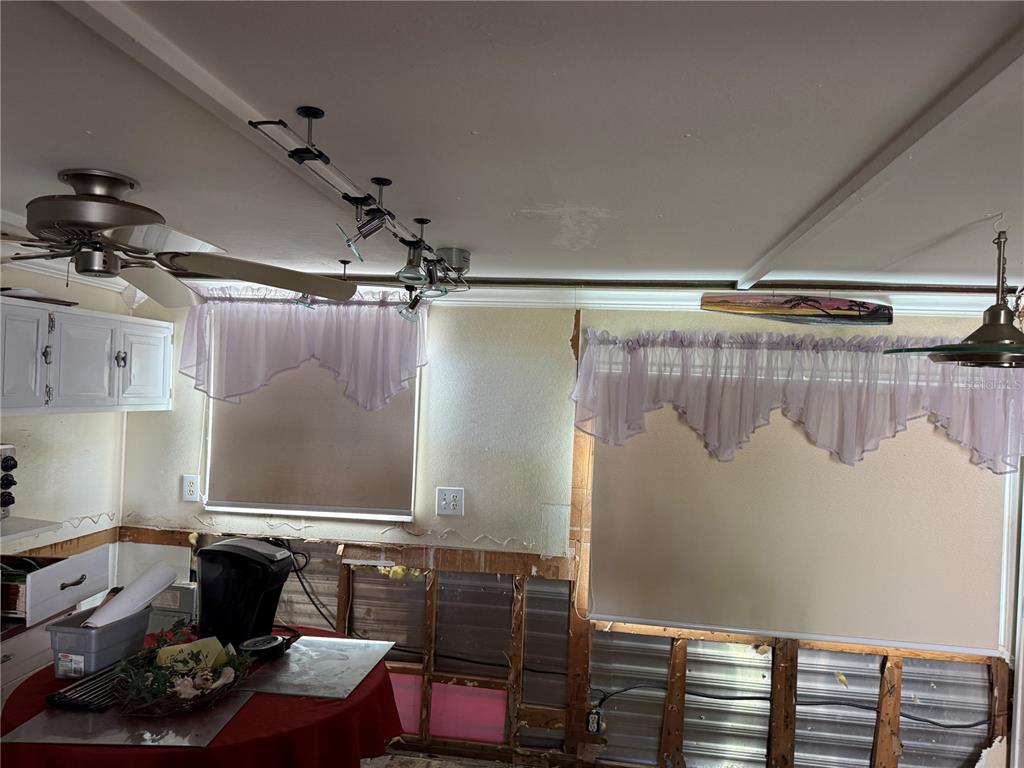 A kitchen area with exposed wall studs, unfinished lower walls, and two windows with valances — 2601 GULF DRIVE N UNIT 502, BRADENTON BEACH, FL
