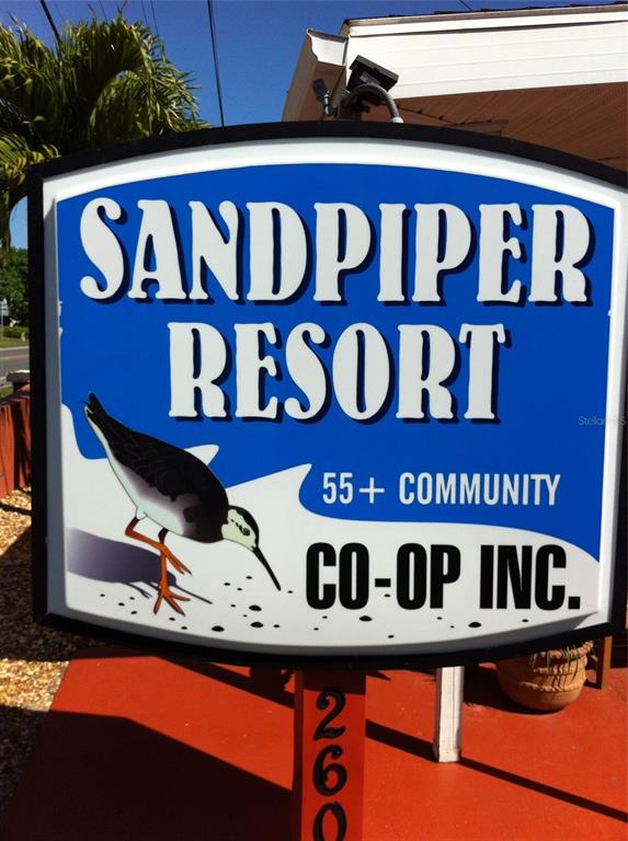 A sign for Sandpiper Resort 55+ Community Co-Op Inc. stands outdoors on a red post — 2601 GULF DRIVE N UNIT 502, BRADENTON BEACH, FL