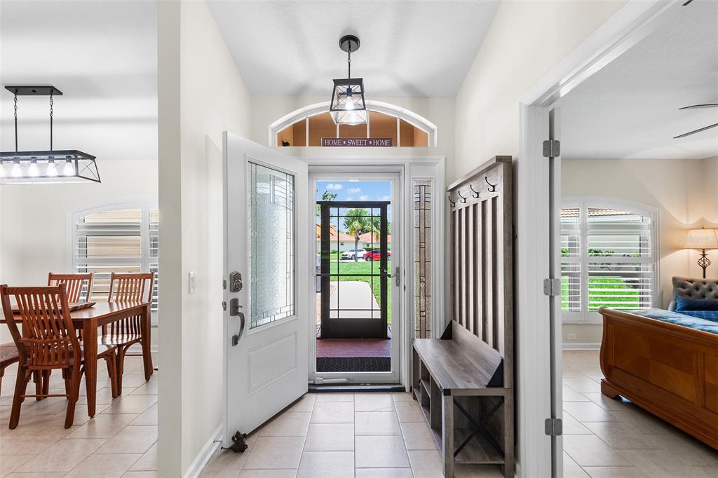 An entryway features a white front door, a wooden hall tree, and tile flooring — 120 MORNING GLORY CIRCLE, WINTER HAVEN, FL