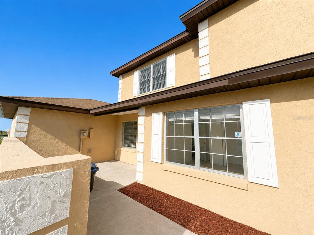 A tan stucco exterior features a concrete walkway, brown trim, and white-shuttered windows — 1255 SOPHIE BOULEVARD, ORLANDO, FL