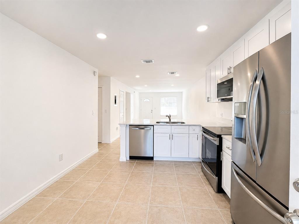 A kitchen with white cabinets, stainless steel appliances, and tile flooring — 1255 SOPHIE BOULEVARD, ORLANDO, FL