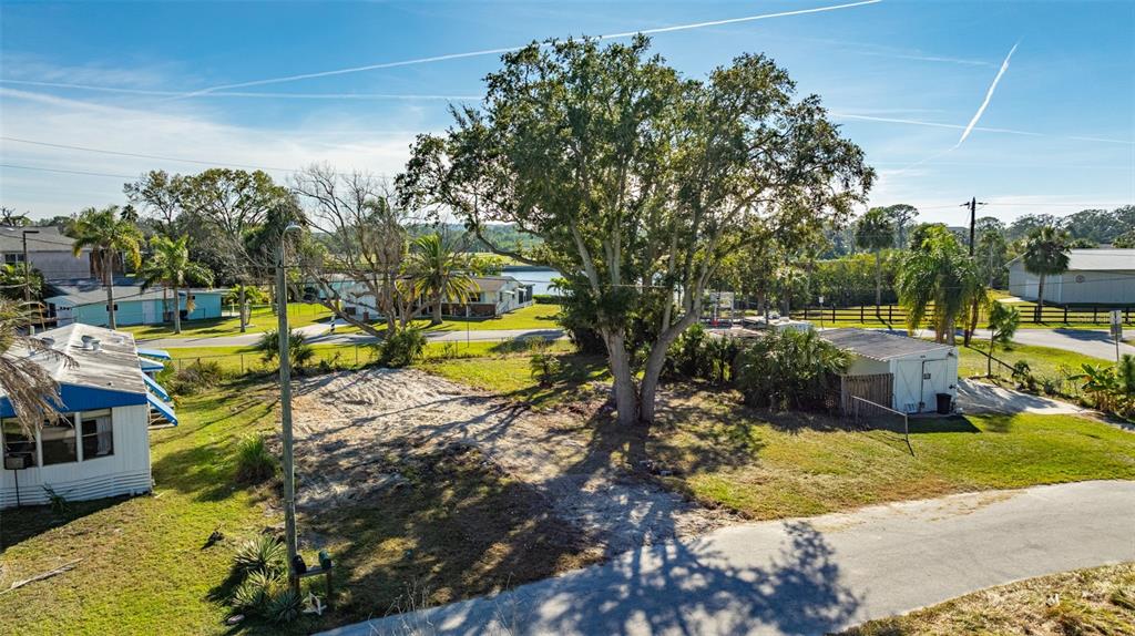 An elevated view shows a vacant lot with a large tree and a small shed — 4836 SNUG HARBOR ROAD, NEW PORT RICHEY, FL