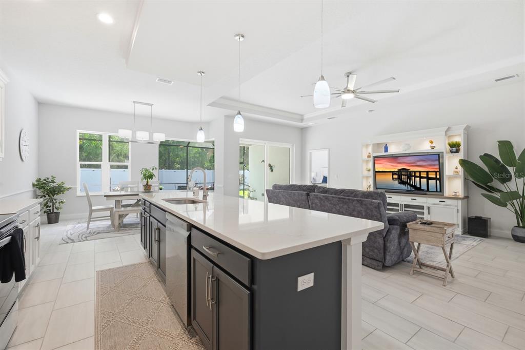 A modern open-concept kitchen and living area with a large island and gray cabinetry — 24 SPRING STREET, PALM COAST, FL