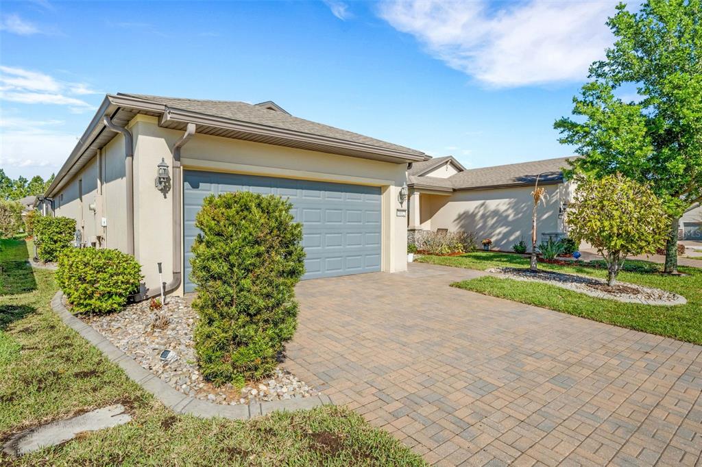 A single-story house with a paved driveway, a two-car garage, and landscaped front yard — 1032 SALAMANCA PLACE, DAVENPORT, FL