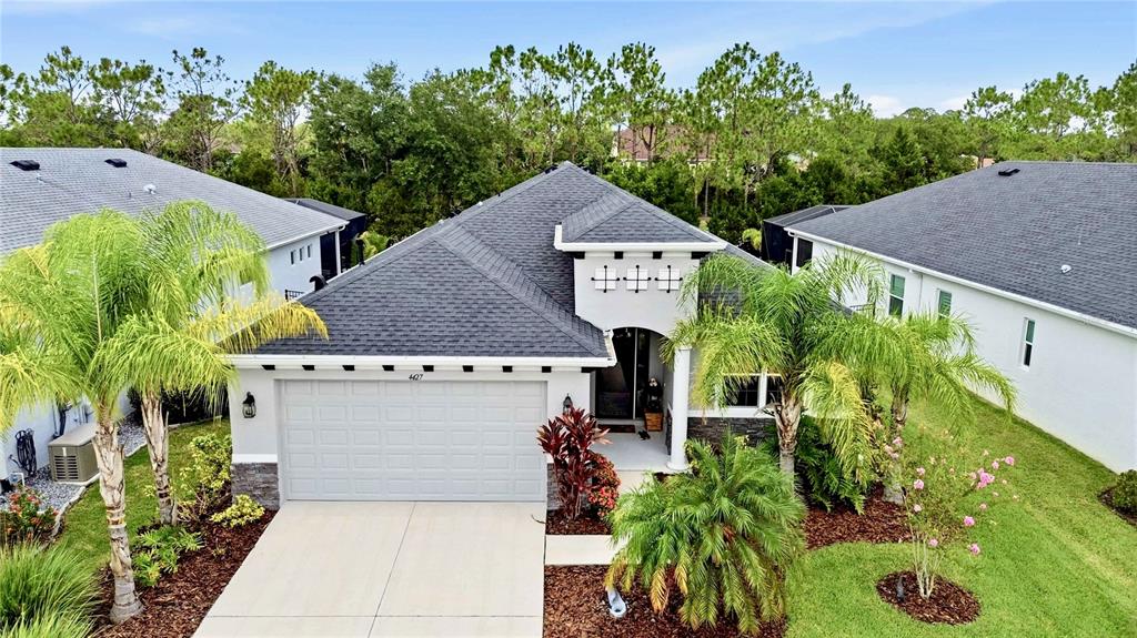 A modern kitchen features dark cabinetry, white countertops, stainless steel appliances, and a central island — 4427 RENWICK DRIVE, PARRISH, FL