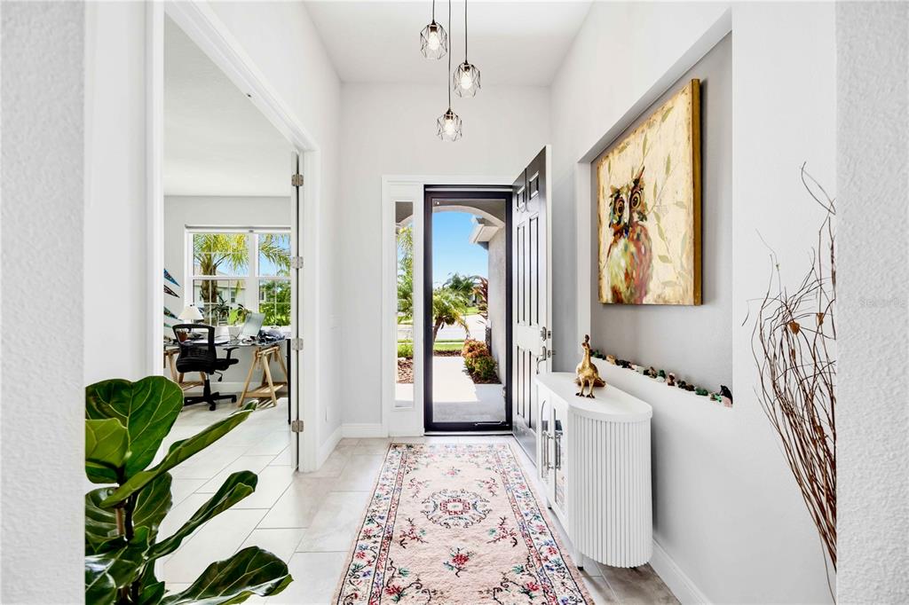 An exterior view of a single-story suburban house with a two-car garage and palm trees — 4427 RENWICK DRIVE, PARRISH, FL