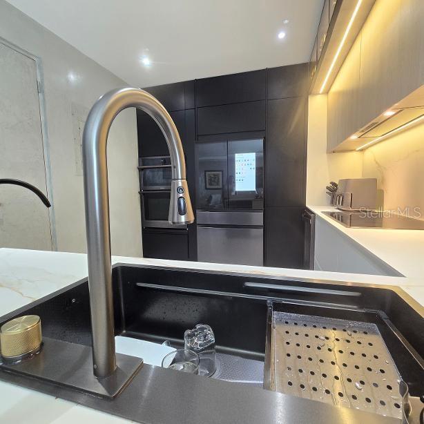 A modern kitchen features a black sink, a stainless steel faucet, and dark cabinetry — 1 RUBI, VEGA ALTA, PR