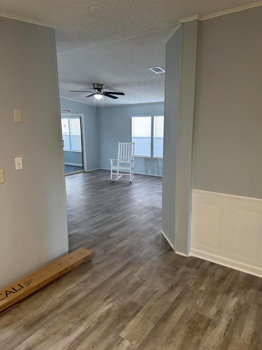 A view through a doorway into a room with light blue walls and wood flooring — 528 Tropical Isles Circle, Fort Pierce FL 34982, FORT PIERCE, FL
