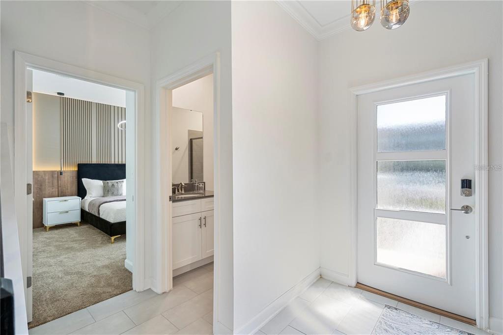 A white front door opens into a tiled entryway with adjacent bedroom and bathroom doorways — 2600 READING TRAIL, KISSIMMEE, FL