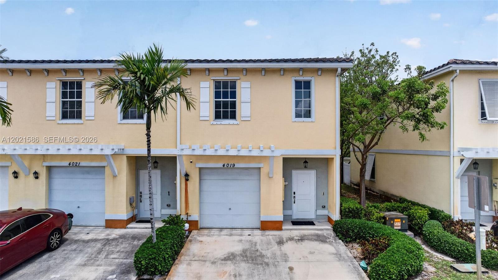 A two-story yellow townhouse exterior features a single-car garage and a small front yard — 4019 NW 11th Dr, Lauderhill FL 33313, LAUDERHILL, FL