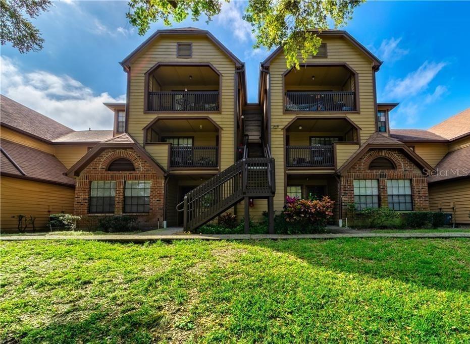 A three-story apartment building with tan siding, brick accents, and exterior staircases — 420 FORESTWAY CIRCLE UNIT 307, ALTAMONTE SPRINGS, FL