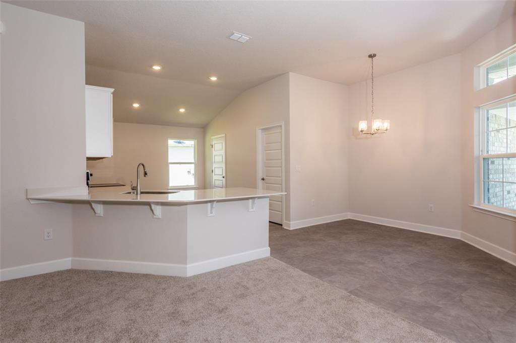 A kitchen with a breakfast bar and an adjacent dining area featuring tile flooring — 79 PORT ROYAL DRIVE, PALM COAST, FL