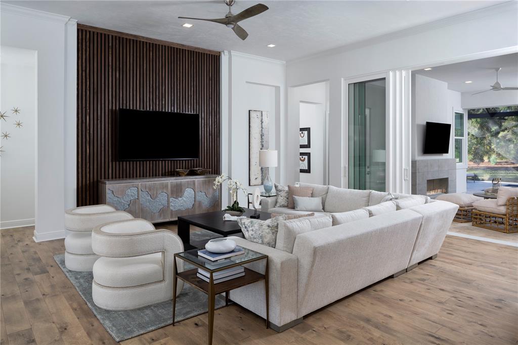 A modern living room features a slatted wood accent wall, sectional sofa, and outdoor patio — 12364 SW 16TH LANE, NEWBERRY, FL