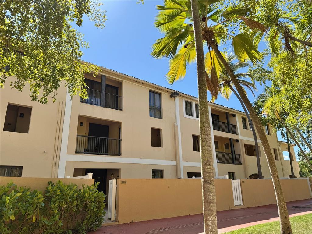 A three-story tan apartment building with balconies and palm trees under a clear blue sky — 999 HARBOURSIDE UNIT 999, HUMACAO, PR