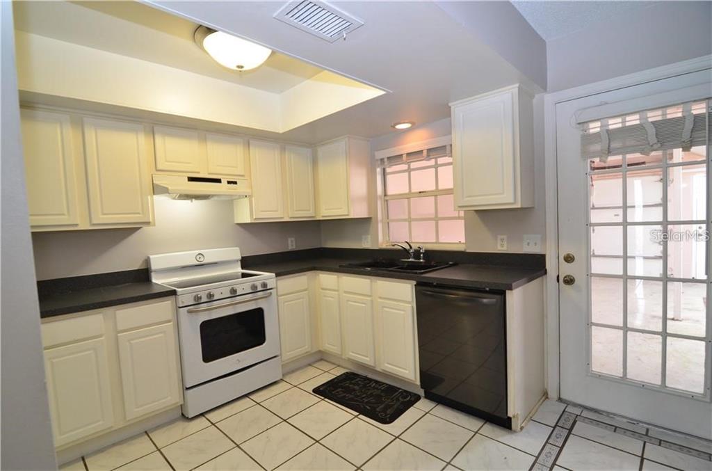 An open-concept living and dining area features white tile flooring and a ceiling fan — 106 S PRIMROSE DRIVE, ORLANDO, FL