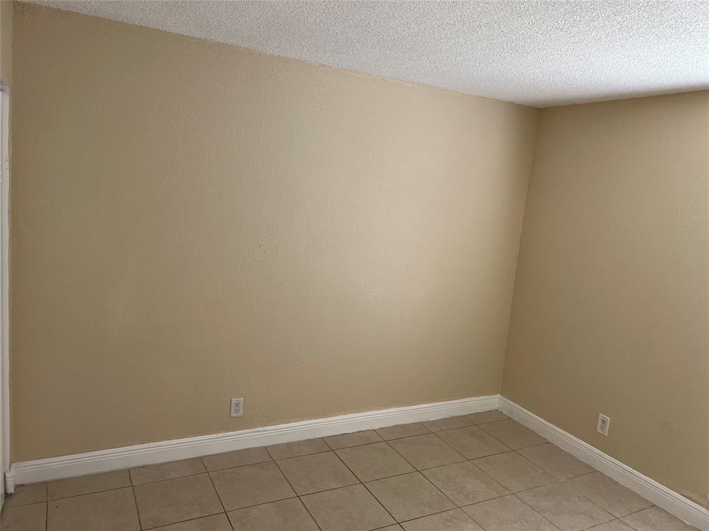 An empty room with beige walls, white baseboards, and light-colored square floor tiles — 4425 Treehouse Lane # A, Tamarac FL 33319, TAMARAC, FL