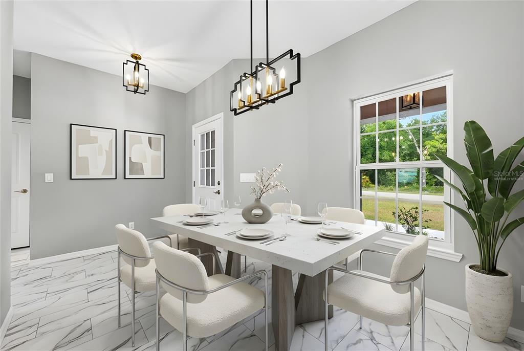 A dining room features a white table, modern chairs, marble-look floors, and two light fixtures — 36 FISHER LANE COURSE, OCKLAWAHA, FL