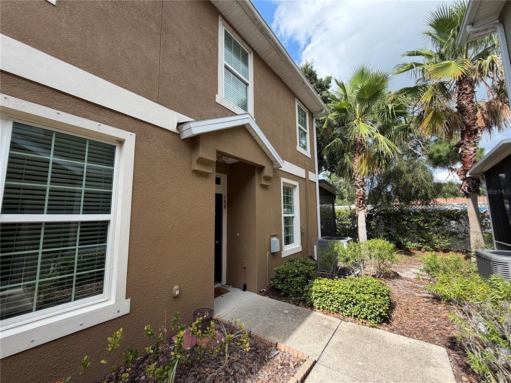 A brown two-story townhouse exterior features a concrete walkway leading to the front entrance — 7001 INTERBAY BOULEVARD UNIT 146, TAMPA, FL