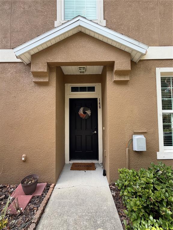 The exterior view shows a tan stucco home entrance with a black door and porch — 7001 INTERBAY BOULEVARD UNIT 146, TAMPA, FL
