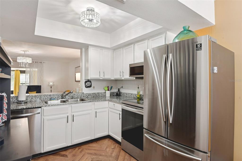 A kitchen with white cabinets, granite countertops, and stainless steel appliances — 14019 NOTREVILLE WAY, TAMPA, FL