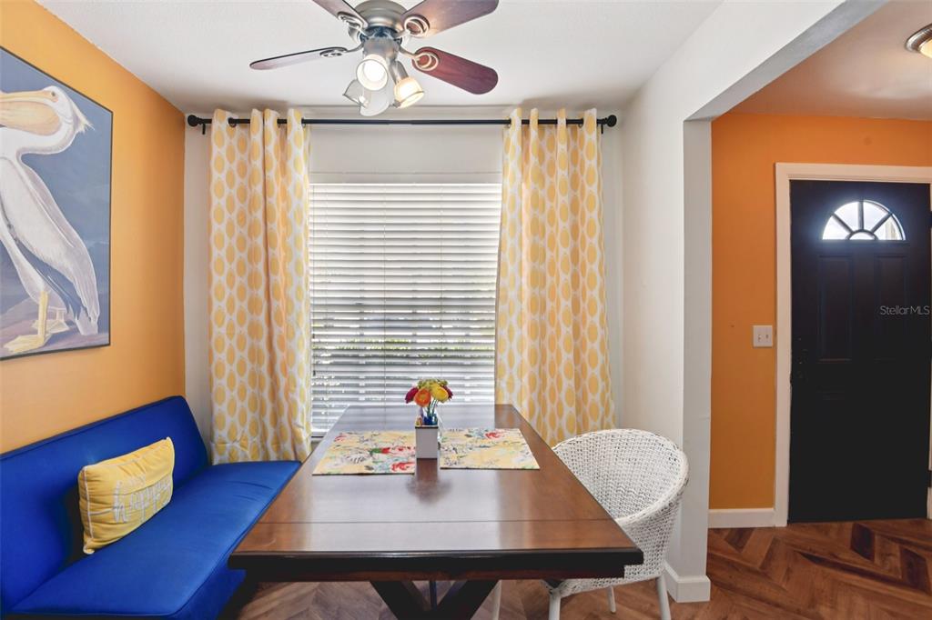 A dining area features a blue bench, a wooden table, and yellow patterned curtains — 14019 NOTREVILLE WAY, TAMPA, FL